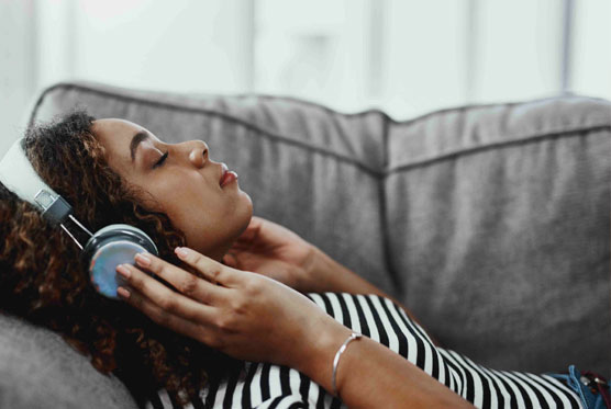 Man on couch meditating with headphones on