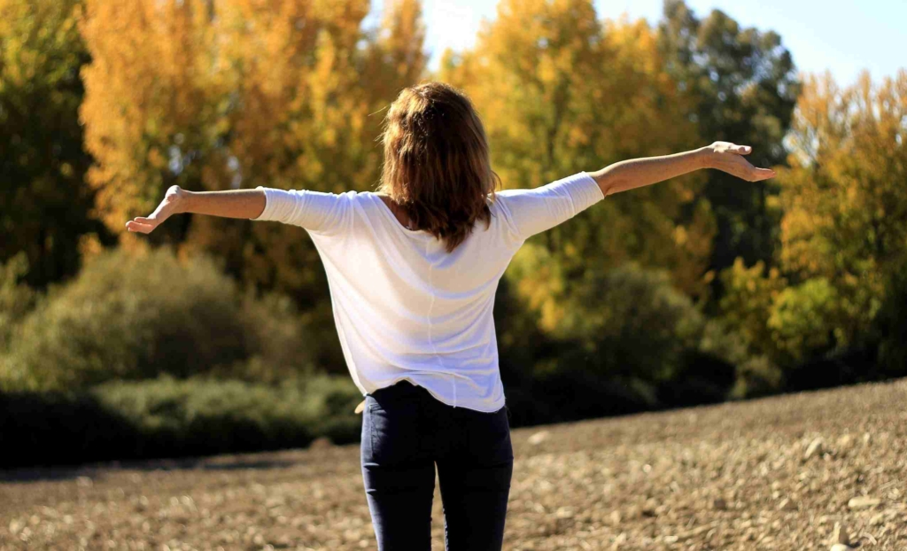 woman with arms outstretched in nature