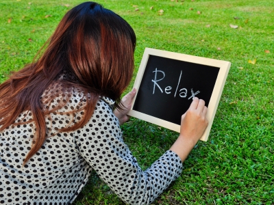 woman writing the word relax on a chalkboard