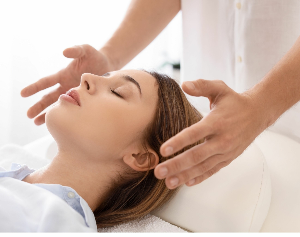 woman lying down receiving a Reiki session