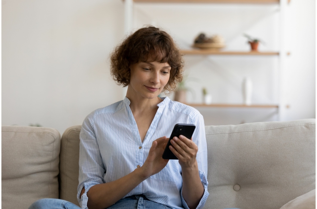 woman using her smartphone on the sofa
