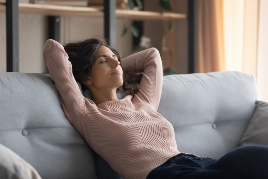 Woman resting on the sofa during a virtual hypnosis session