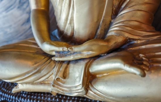 close up of buddha statue hands in meditation