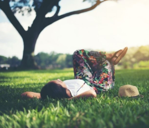 Woman lying in grass looking relaxed on a summer day