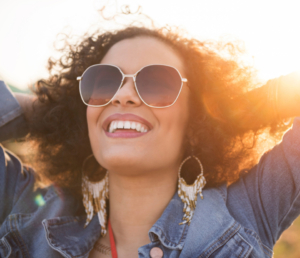 Woman with sunglasses smiling in the sun