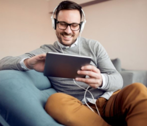 Man wearing headphones smiling looking at tablet