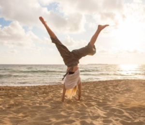 Woman doing a cartwheel at the beach