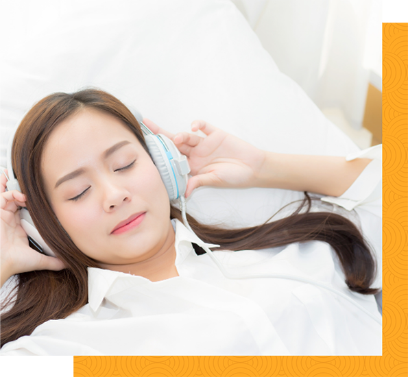 Woman with eyes closed and headphones on listening to a session