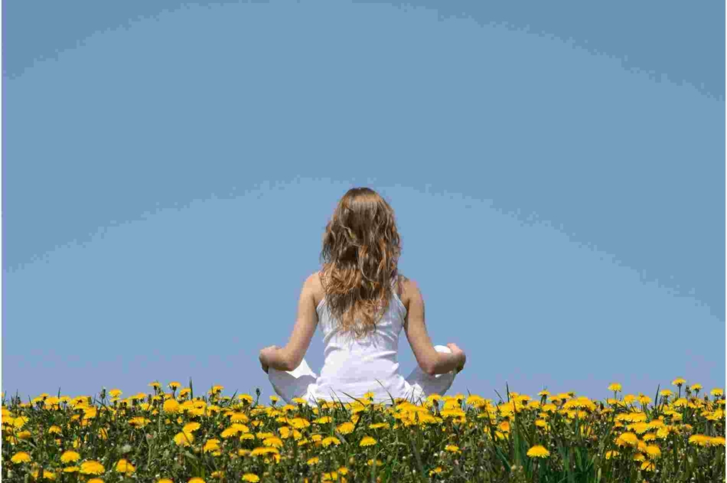 woman sitting the field of flowers 